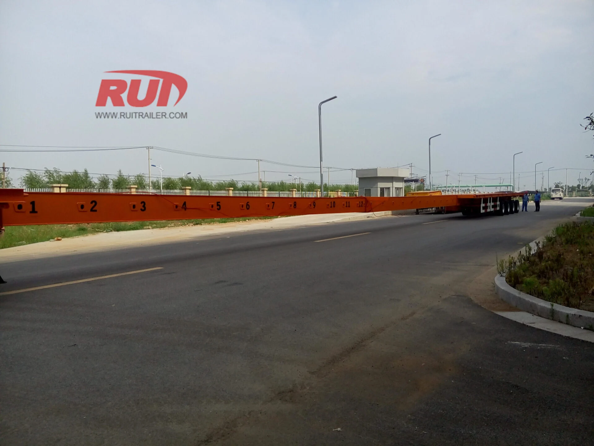 Specialized trailer transporting wind turbine blades at sunrise