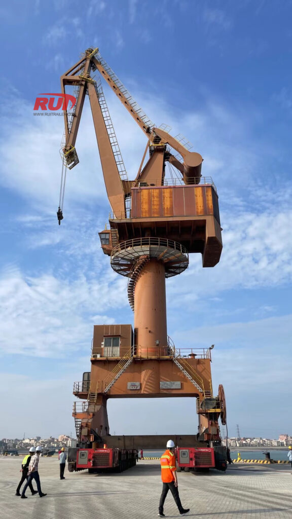 Selbstfahrende modulare Transporter (SPMT) bewegen Hafenkräne