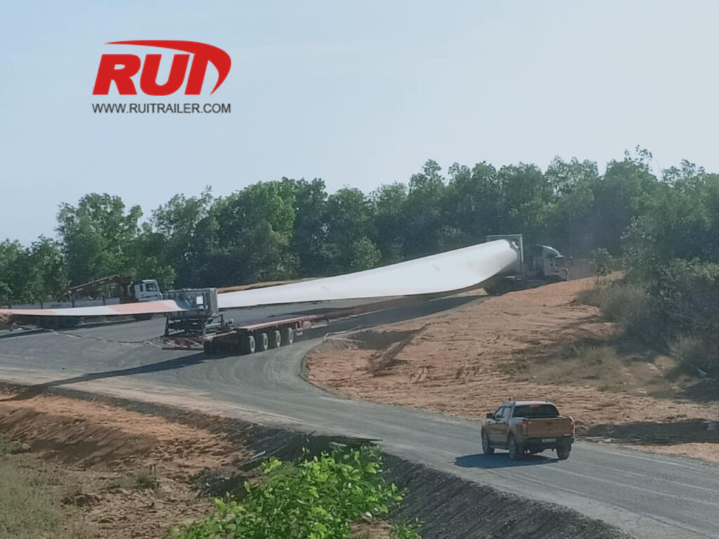 Self-propelled wind blade adapter trailer during intra-plant transport